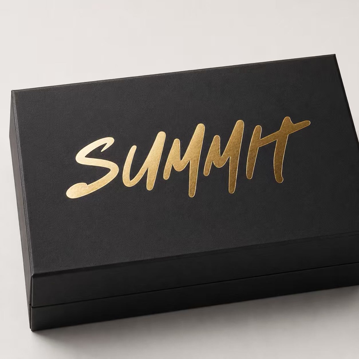 Gold foil Summit logo on a black presentation box